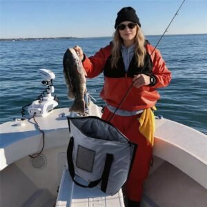 Fishing Cooler Bag on Offshore Boat - Fmosbag - Oem Bag Manufacturer & Custom Bag Factory Fishing Cooler Bag on Boat Deck, Female Angler Holding a Fresh Catch with Grey Insulated Fish Bag Open Beside Her - Fmosbag - Oem Bag Manufacturer & Custom Bag Factory